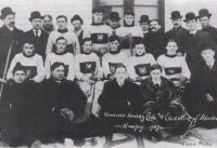 Several rows of men, some wearing hockey uniforms, the others in overcoats and top hats.